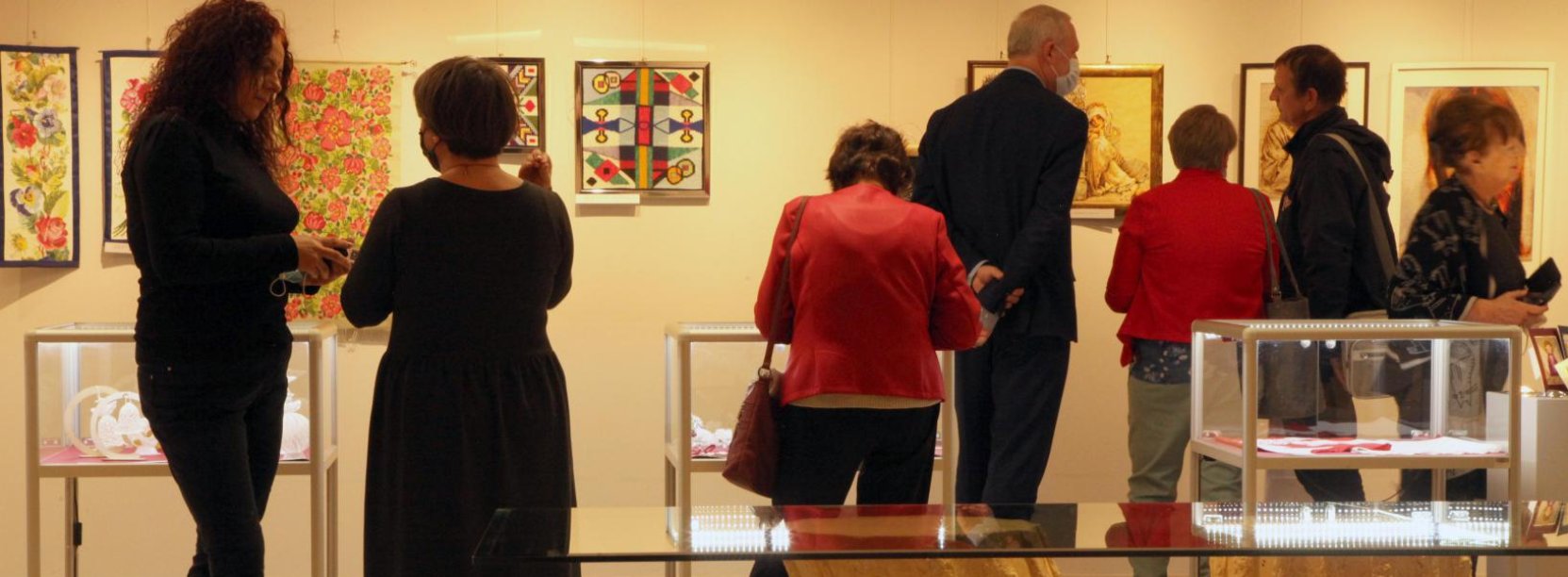 grupa ludzi oglądajacych wystawę w galerii na piętrze DOK