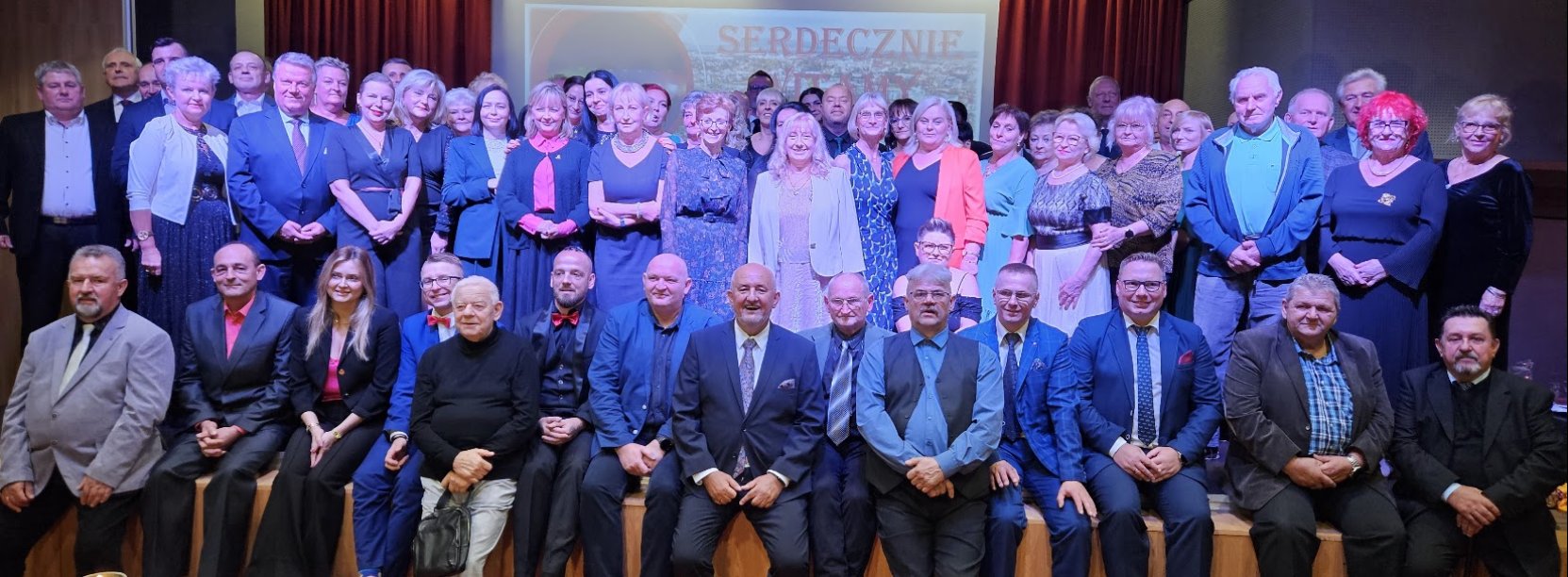 duża grupa osób - byłych i obecnych pracowników dzierżoniowskiego OSiR-u oraz samorządowcy na scenie w sali koncertowej DOK