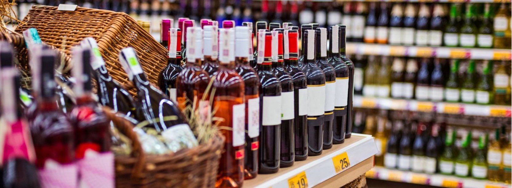 sklep z alkoholem, na półka stoją rzędy butelek w różnych kolorach