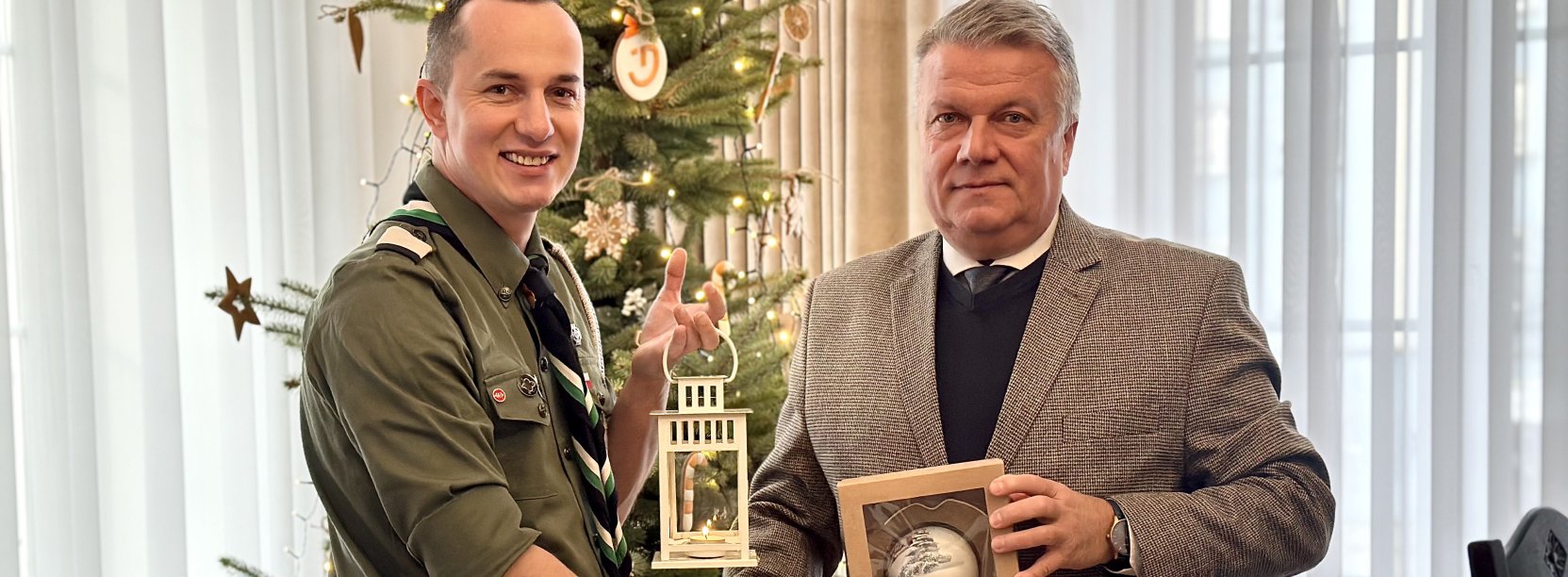 ć zdjęcie przedstawiające moment przekazania światła, burmistrza z komendantem Tomaszem Tkaczem przy płomieniu