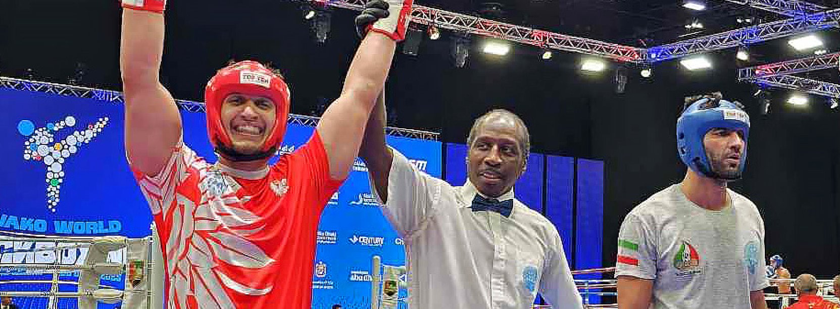 Maks Palej na ringu z uniesionymi rękami w geście zwycięstwa, obok sędzia i przeciwnik