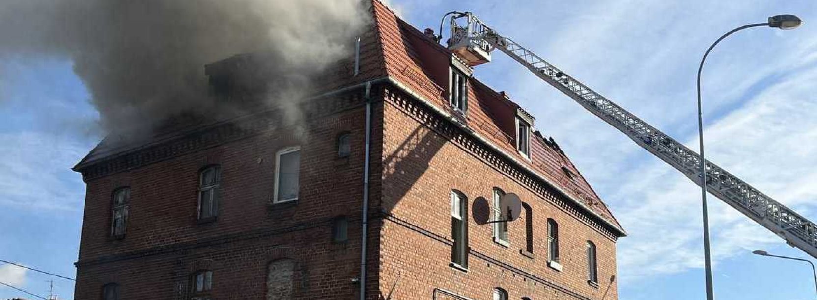 płonący budynek przy ul. Brzegowej 85 w Dzierżoniowie, kłęby dymu z dachu