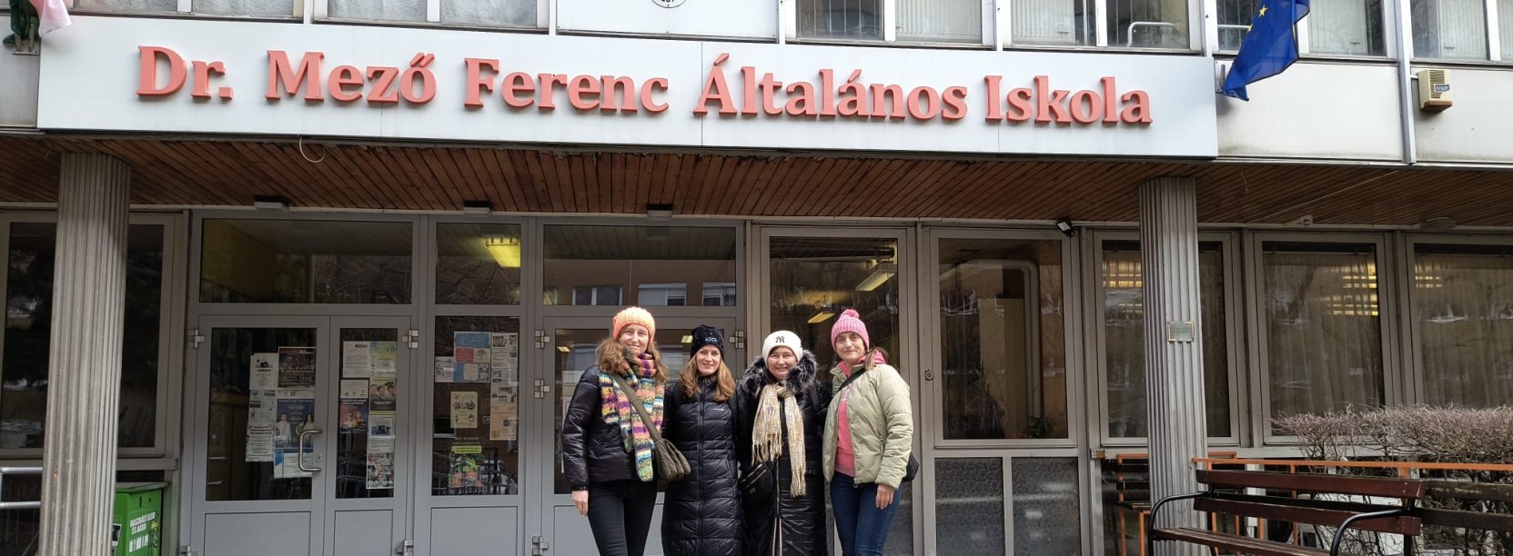 Trzy kobiety przed budynkiem szkoły