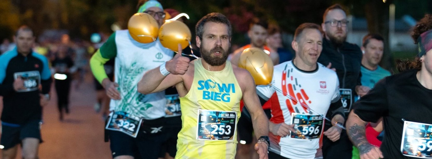 Kilkanaście osób biegnących nocą po ulicy