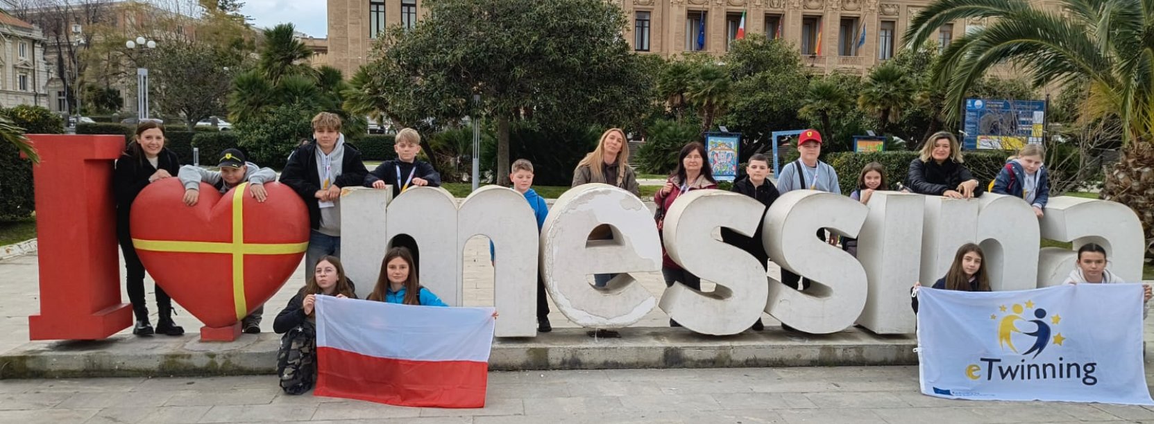 Duże litery I love Messina na tle miasta, przy literach stoją dzieci