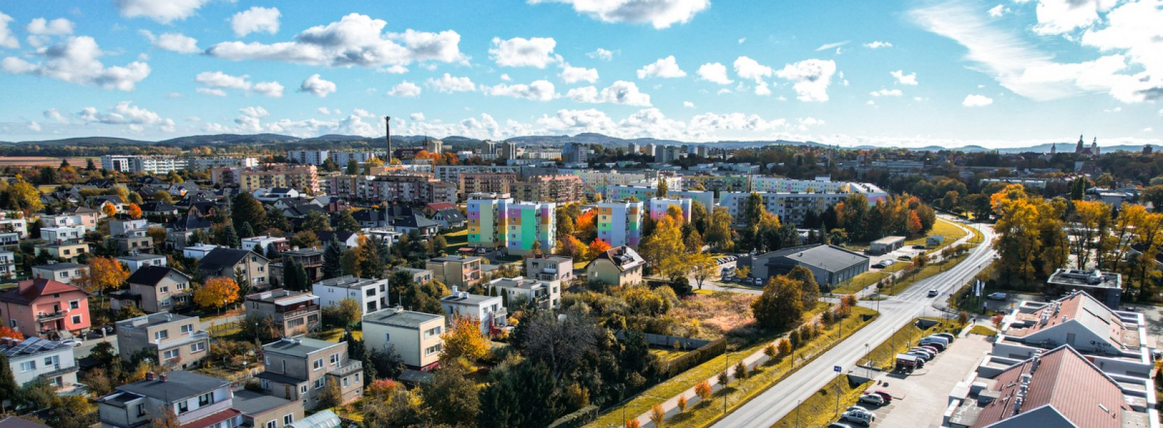 Dzierżoniów z lotu ptaka, za miastem góry i błękitne niebo