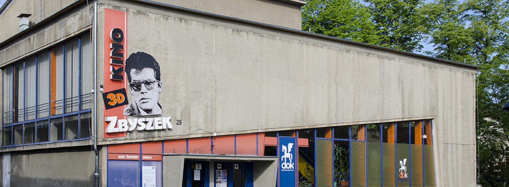 Budynek kinoteatru z przodu, na ścianie duże zdjęcie Zbigniewa Cybulskiego