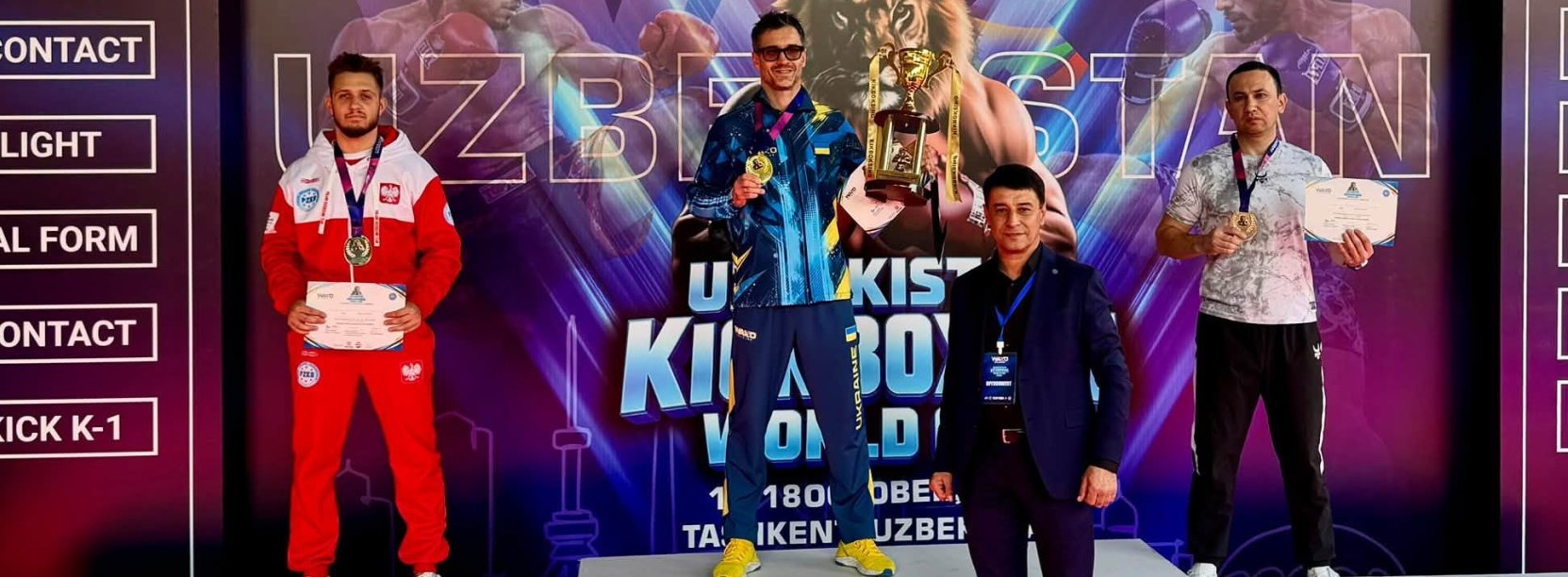 Maksymilian Palej w biało-czerwonym stroju reprezentacji Polski stoi na drugim miejscu podium. Za nim napis Uzbekistan