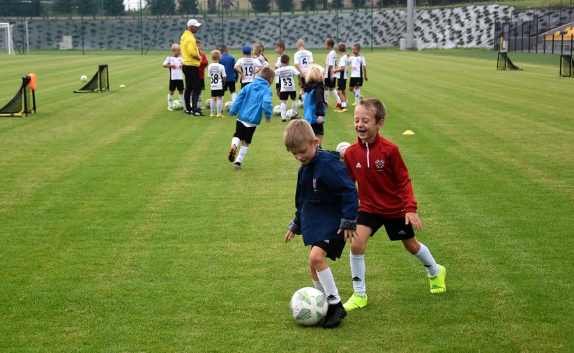 Młodzi piłkarze grają ze sobą na płycie stadionu