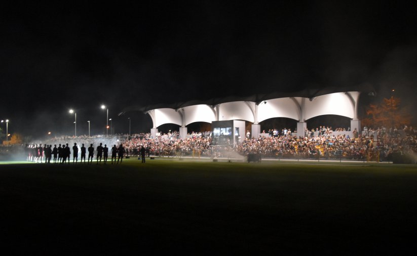 Stadion nocą i z podświetloną trybuną wypełniona kibicami