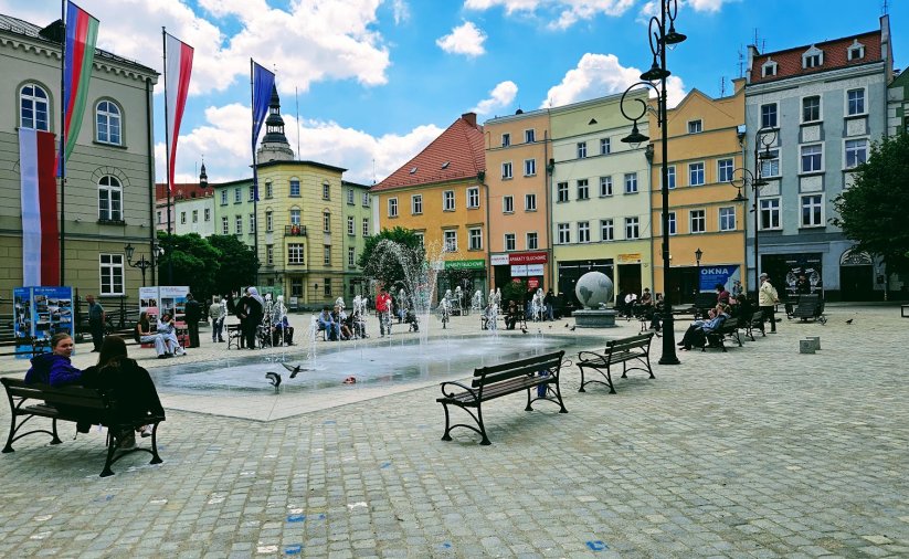 Fontanna posadzkowa na rynku, obok ławki