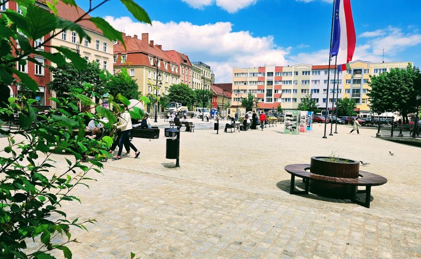 Fragment rynku, w tle kamienice i budynek wielorodzinny