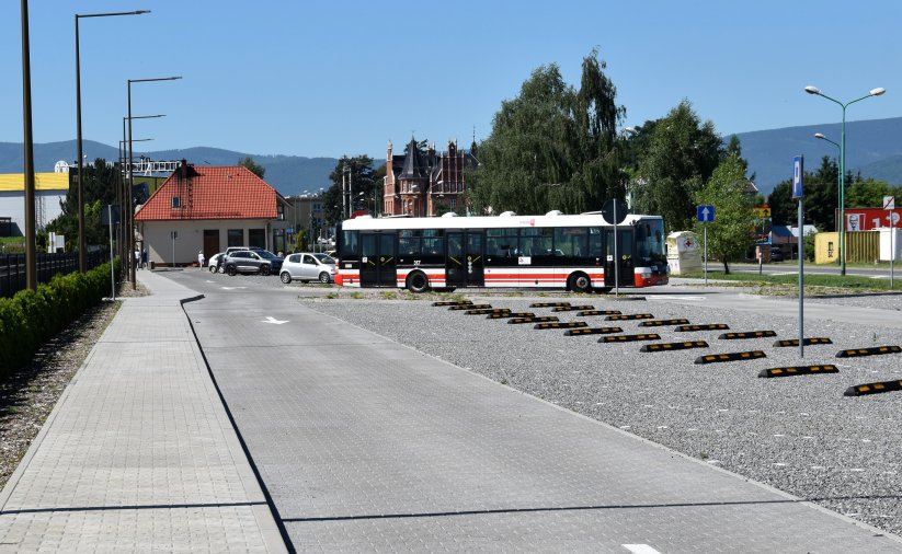 Duży parking przy cmentarzu, w tle autobus komunikacji miejskiej