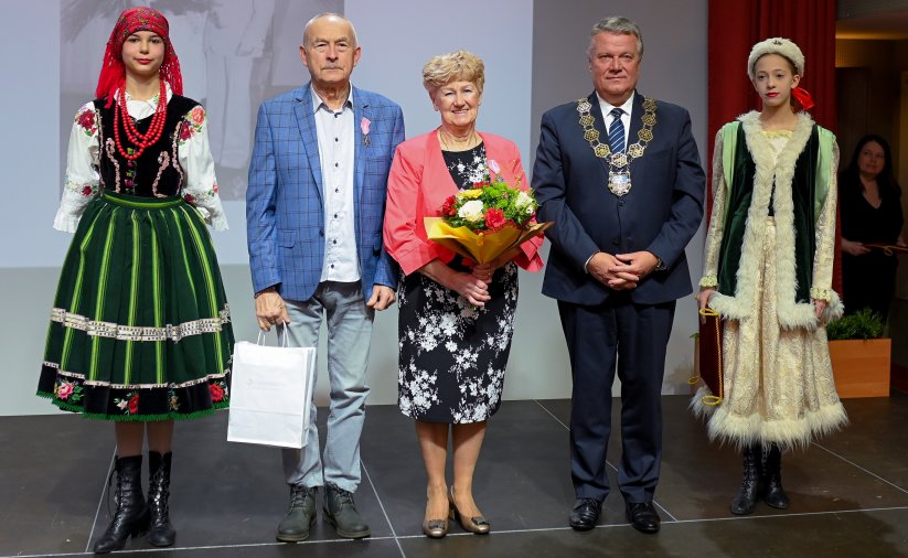 Para jubilatów z burmistrzem, po bokach dwie dziewczyny w strojach ludowych