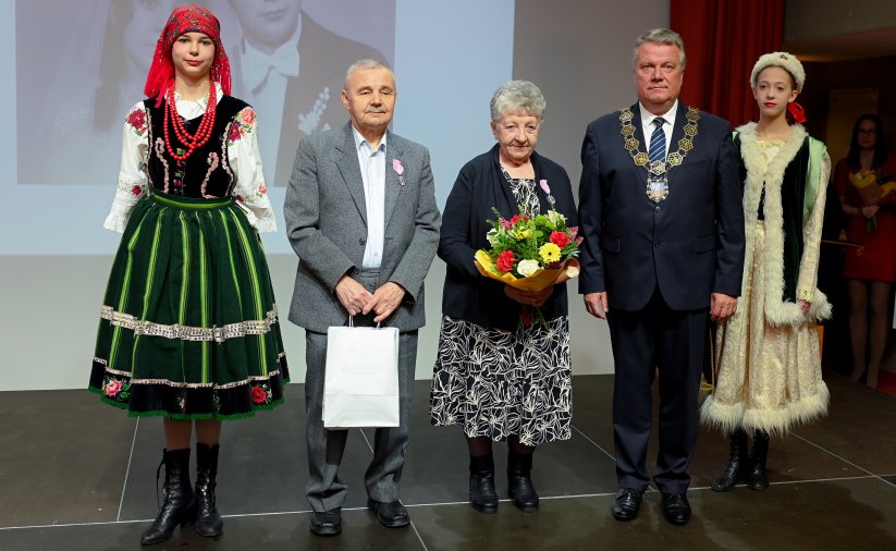 Para jubilatów z burmistrzem, po bokach dwie dziewczyny w strojach ludowych
