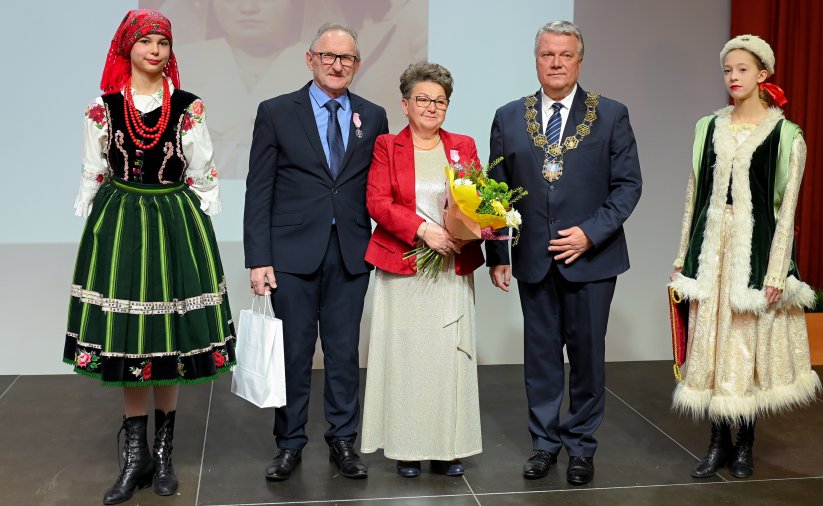 Para jubilatów z burmistrzem, po bokach dwie dziewczyny w strojach ludowych