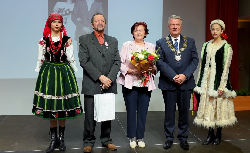 Para jubilatów z burmistrzem, po bokach dwie dziewczyny w strojach ludowych