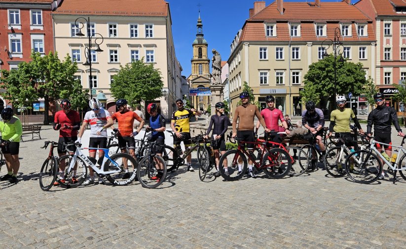 Grupowe zdjęcie kilkunastu rowerzystów przed wyruszeniem na trasę