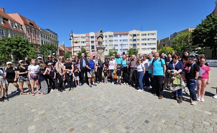 Grupowe zdjęcie około trzydziestu rowerzystów na rynku