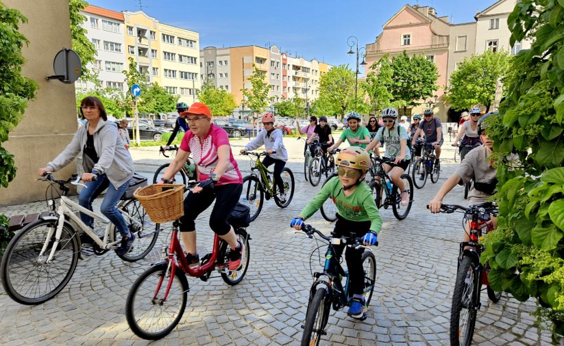 Grupa rowerzystów wyjeżdzająca z rynku