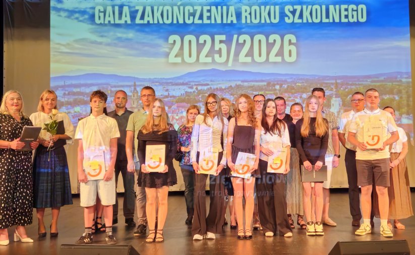 Grupa młodych mieszkańców na scenie. Każdy trzyma w rękach dyplom