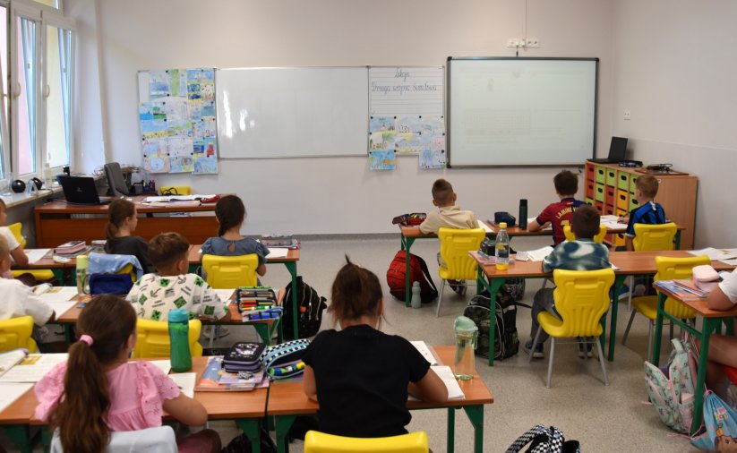 Uczniowie podczas lekcji siedzący na żółtych krzesłach