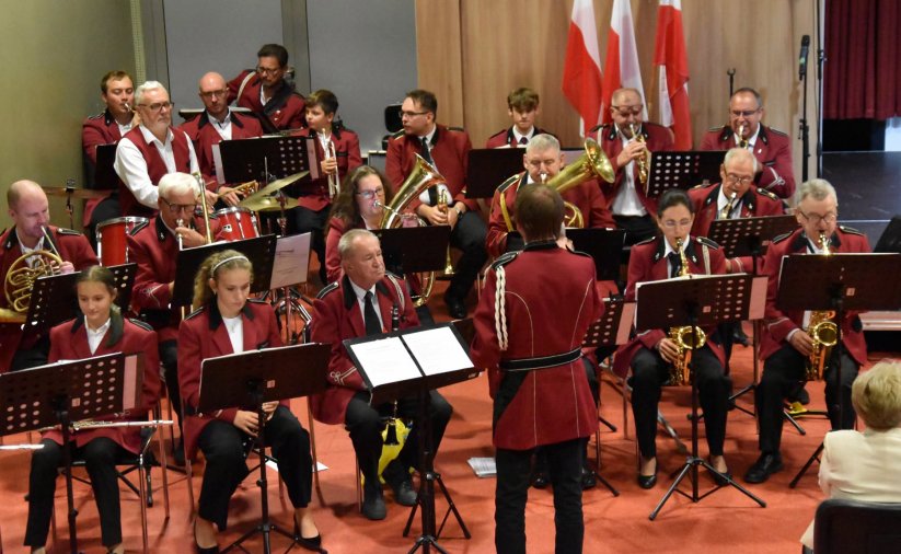 Orkiestra w jedakowych bordowych strojach podczas występu