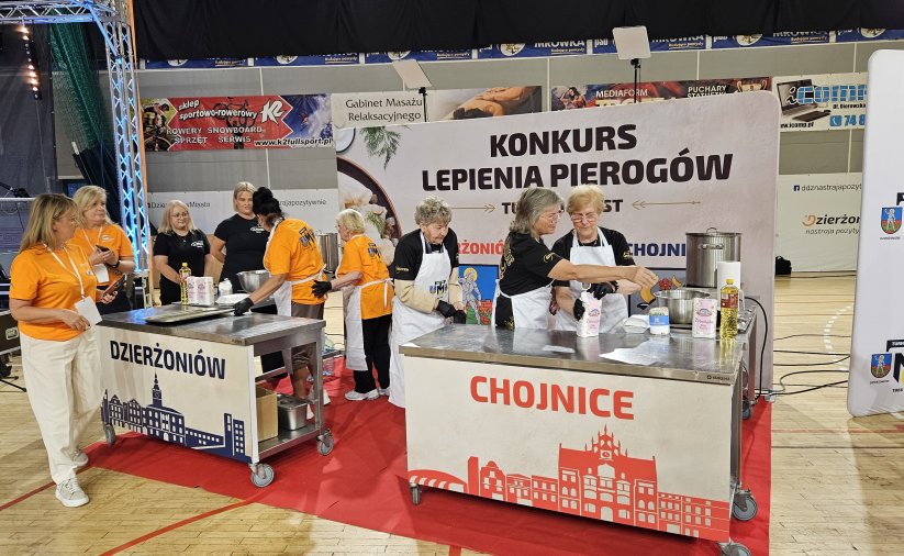 Dwa duze stoły, przy nich kobiety lepiące pierogi