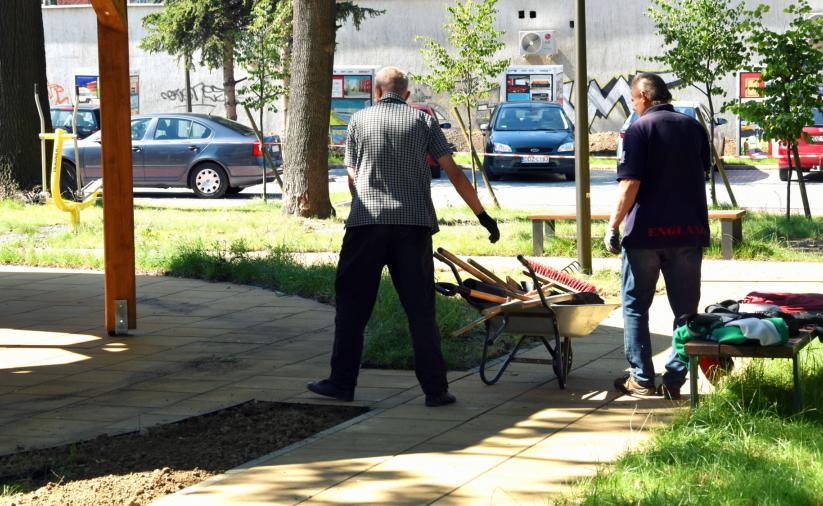 Dwóch bzerobotnych sprzątających teren Centrum Seniora w Dzierżoniowie