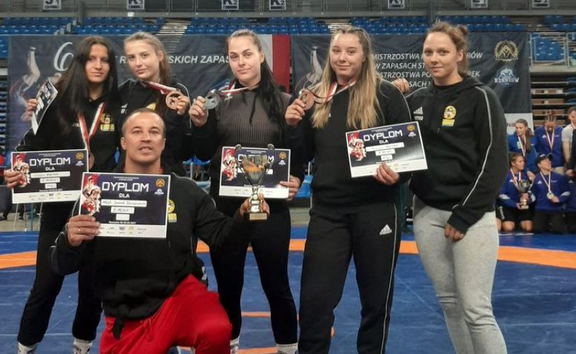 Zawodniczki i trener w sportowych strojach