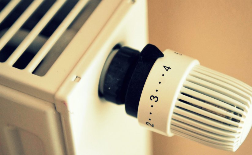 Biały kaloryfer z pokrętłem do regulacji temperatury 