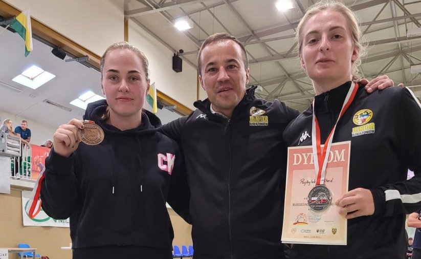 Trener i dwie zawodniczki na wspólnym zdjęciu