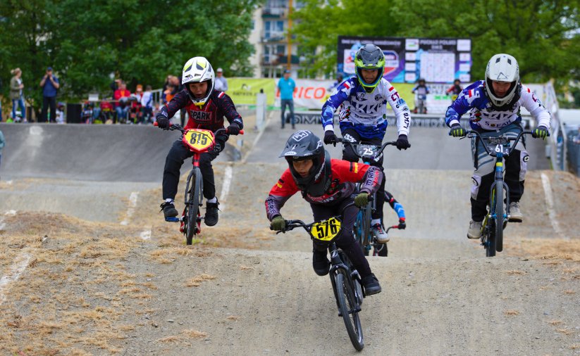 Czwórka młodych rowerzystów jadących po torze BMX