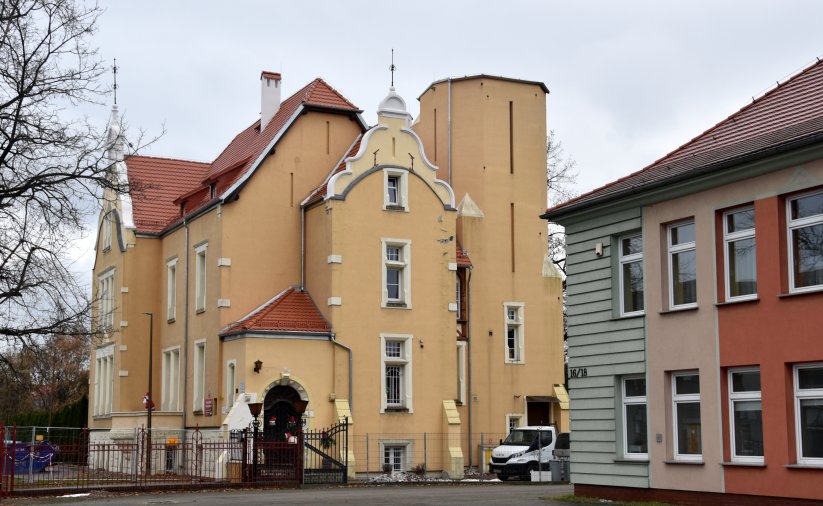 Zółta kamienica z nowym dachem z czerwonej dachówki