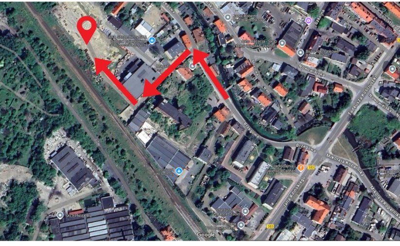 Fragment miasta widziany z góry, czerwonymi strzałkami zaznaczonao miejsce dojazdu do odbioru worków i piasku