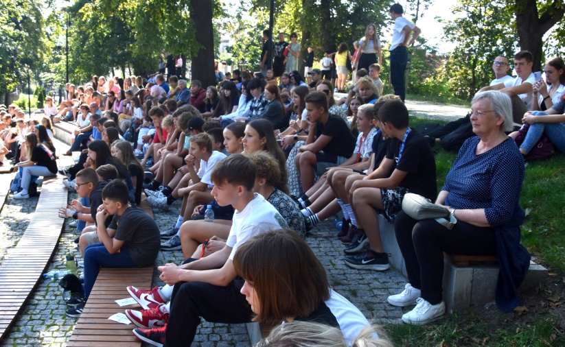 Młodzi ludzie siedzący na ławkach amfiteatru w parku