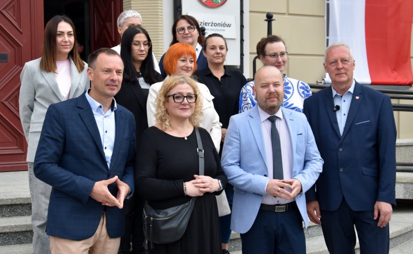 Grupa osób przed wejściem do ratusza na wspólnym zdjęciu