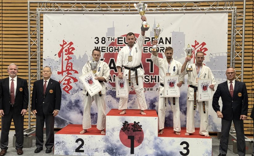 Tomasz Staściuk na najwyższym stopniu podium z uniesionym do góry pucharem