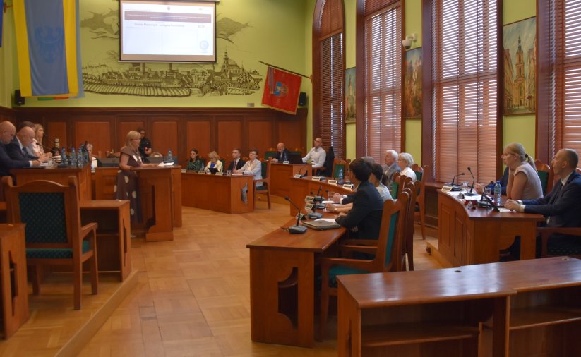 Grupa radnych na sali rycerskiej ratusza podczas sesji rady miejskiej