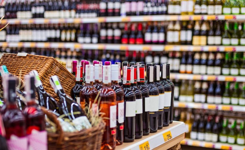 sklep z alkoholem, na półka stoją rzęsdy butelek w różnych kolorach