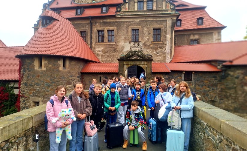 Grupa uczniów na tle zamku