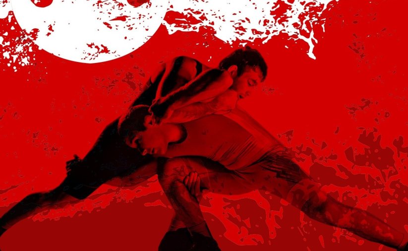 Starcie dwóch zapaśników na biało-czerwonym tle