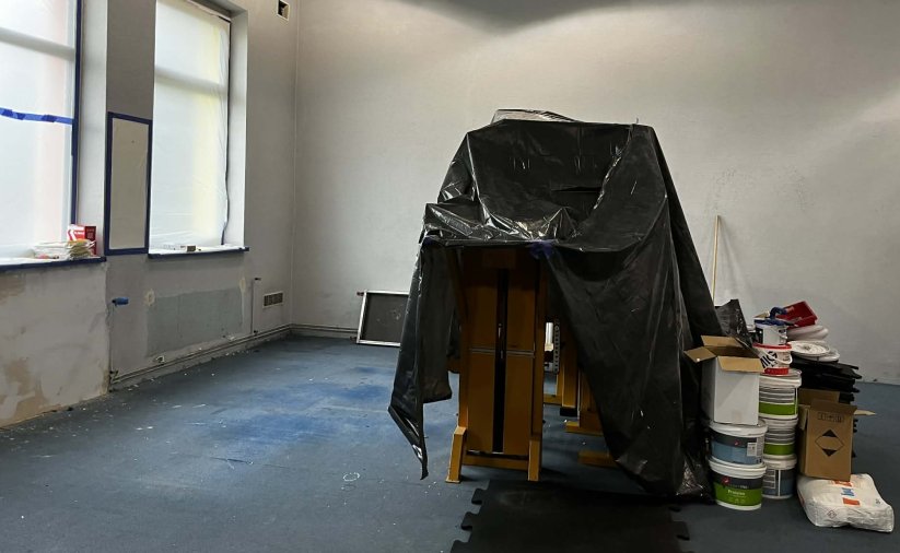 Pomieszczenie siłowni w remoncie, sprzęty zakryte folią malarską