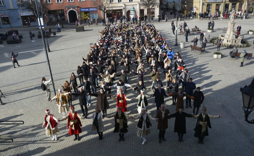 Duża grupa tanczących poloneza osób na płycie rynku