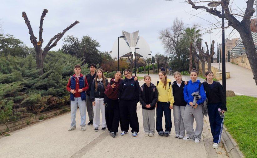 10 uczniów SP 9 na deptaku, w tle futurystyczny budynek