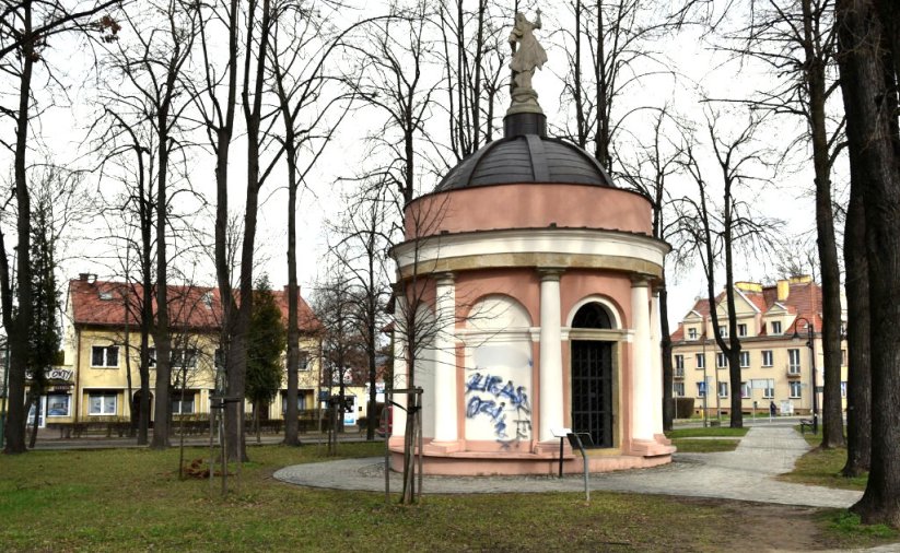 Niewielka, okrągła kaplica w parku, z rzeźbą kobiety wieńczącej kopułę