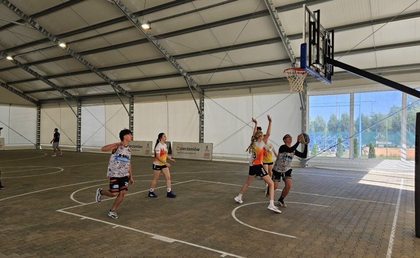 grupa młodziezy gra w koszta w hai namiotowej