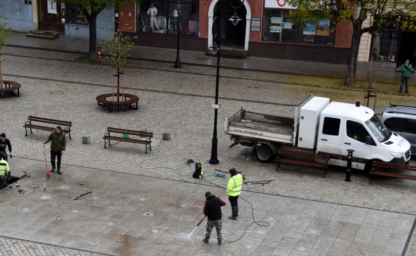 Pięciu pracowników czyści i sprawdza fontannę posadzkową