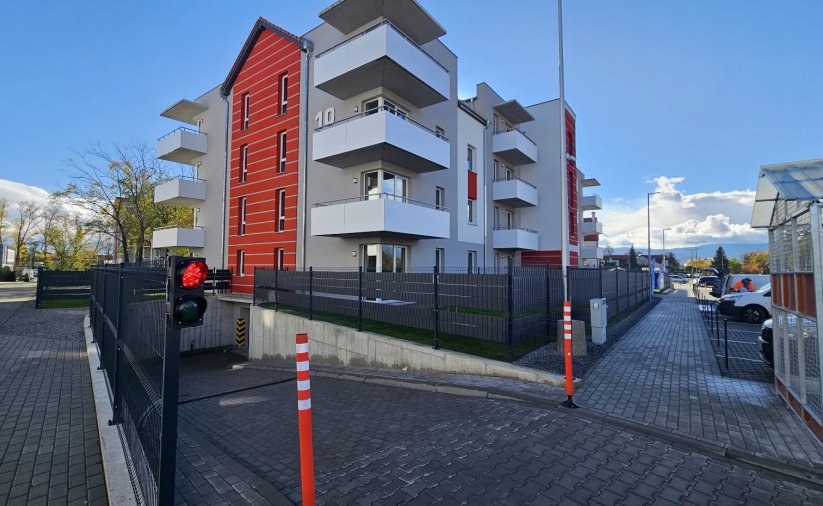 Czteropiętrowy udynek TBS-u, z dużymi balkonami i ogrodzeniem wokół