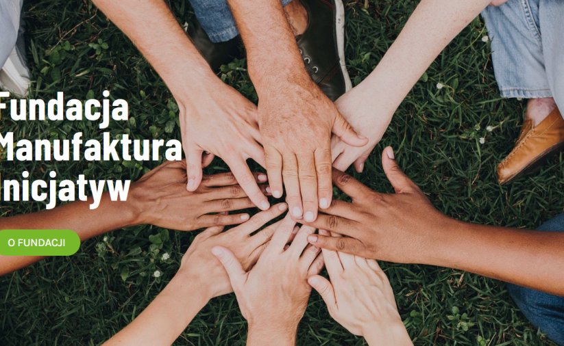Osiem stykających się dłoni i na tle trawy i napis Fundacja Manufaktura Inicjatyw